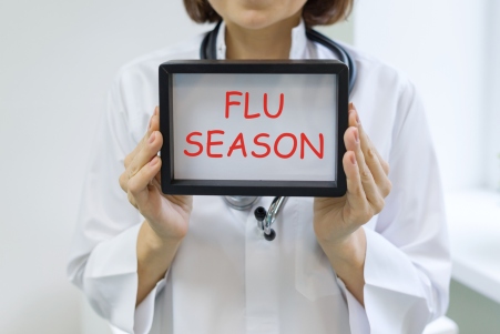 Flu season text in the hands of a female doctor